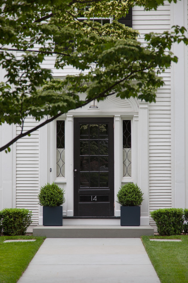 Example of a classic entryway design in Boston with a black front door
