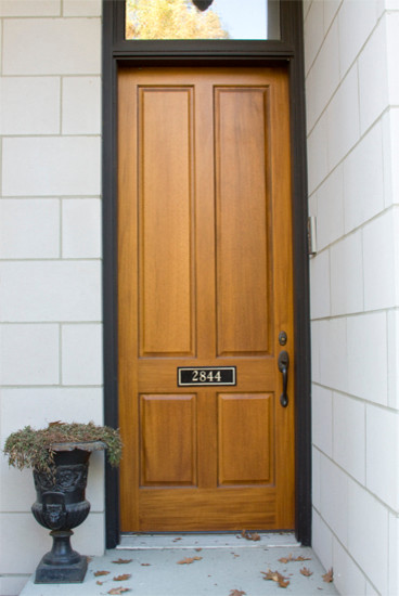 Идея дизайна: большая входная дверь в классическом стиле с серыми стенами, бетонным полом, одностворчатой входной дверью и входной дверью из дерева среднего тона