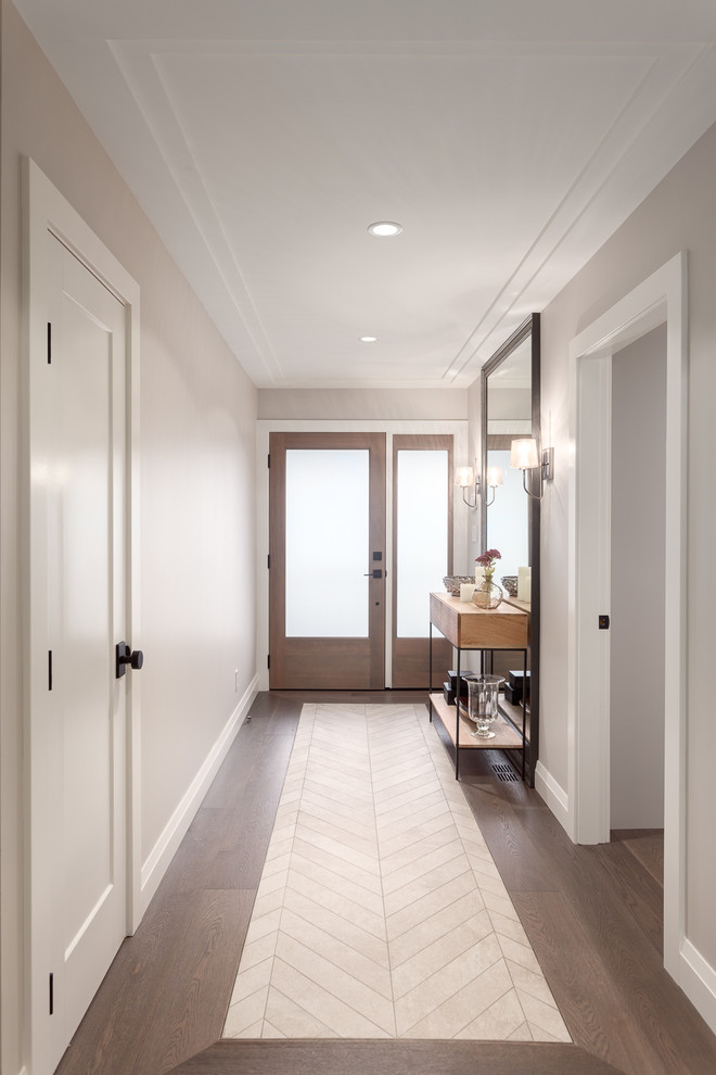 Photo of a medium sized contemporary hallway in Vancouver with beige walls, dark hardwood flooring, a single front door, a medium wood front door and brown floors.