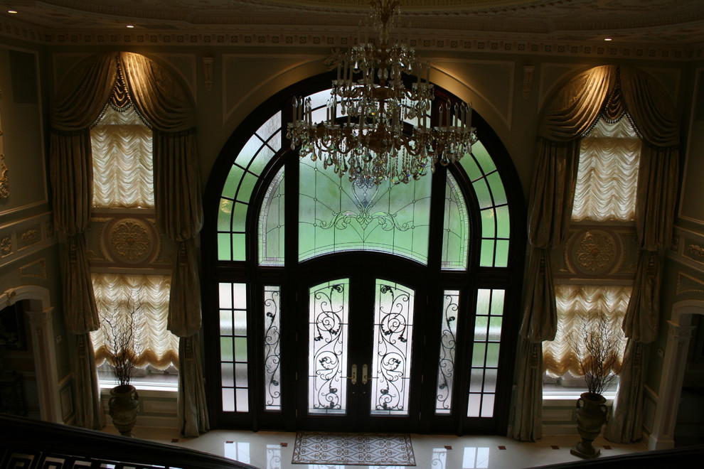 Пример оригинального дизайна: огромное фойе в классическом стиле с бежевыми стенами, мраморным полом, двустворчатой входной дверью и черной входной дверью