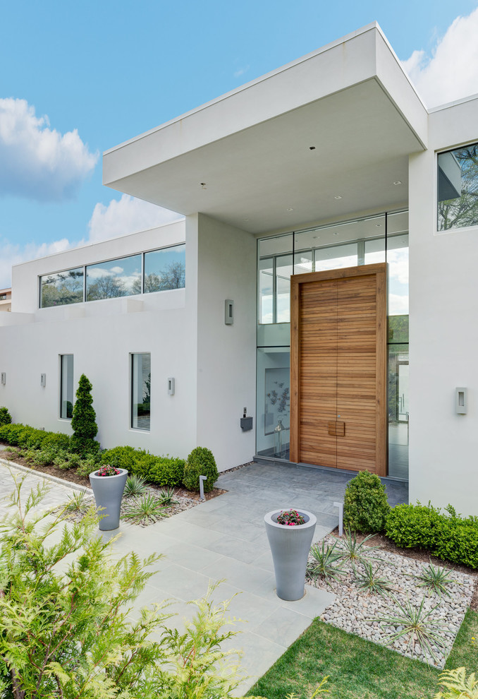 Imagen de puerta principal contemporánea con paredes blancas, puerta doble, puerta de madera en tonos medios y suelo gris