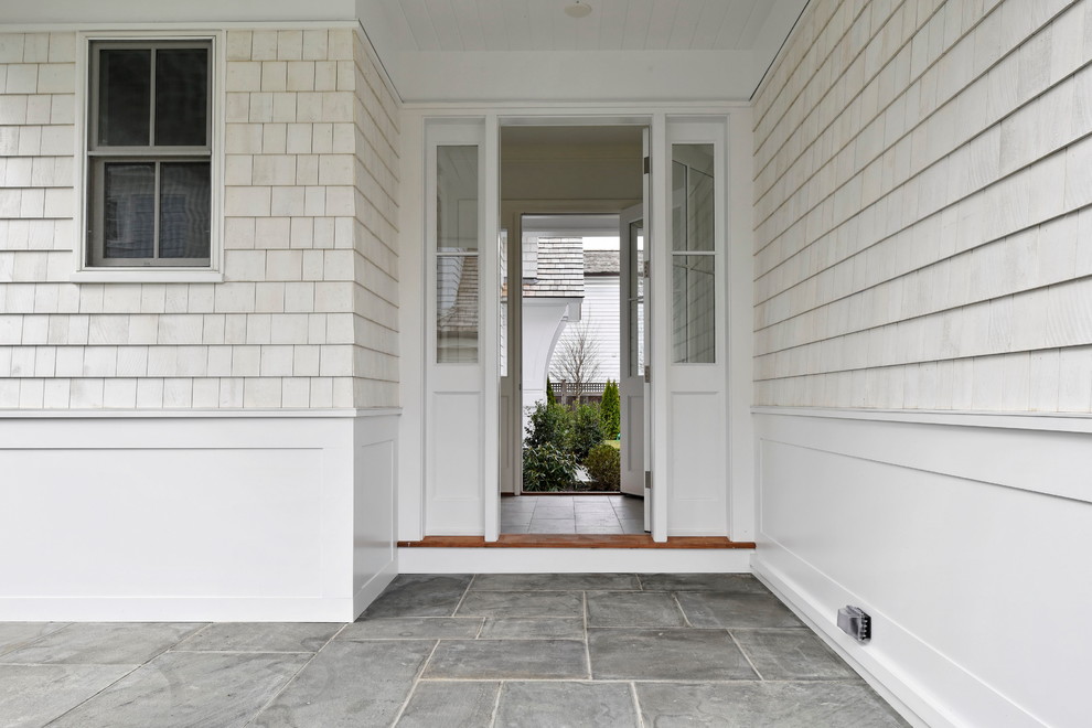 This is an example of a large classic front door in New York with white walls, slate flooring, a single front door, a white front door and grey floors.