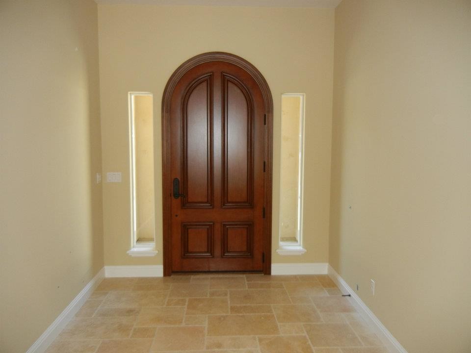 Example of a mid-sized classic limestone floor and black floor entryway design in Sacramento with beige walls and a dark wood front door