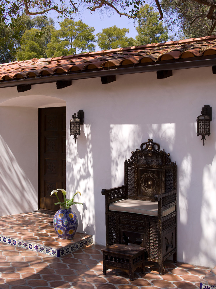 Entryway - large mediterranean terra-cotta tile entryway idea in Los Angeles with white walls and a dark wood front door