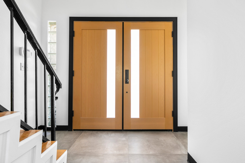 Foto de puerta principal contemporánea de tamaño medio con paredes blancas, suelo de baldosas de porcelana, puerta doble, puerta de madera clara y suelo gris