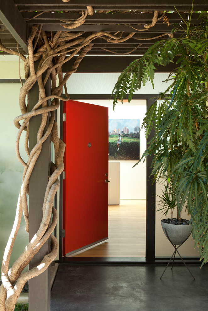 ロサンゼルスにあるラグジュアリーな広いミッドセンチュリースタイルのおしゃれな玄関ドア (コンクリートの床、赤いドア、グレーの床) の写真