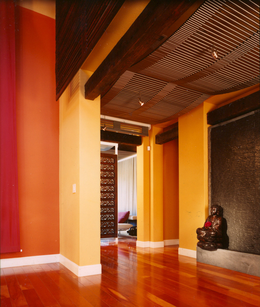 Foto di un ingresso o corridoio etnico con pareti arancioni e parquet scuro