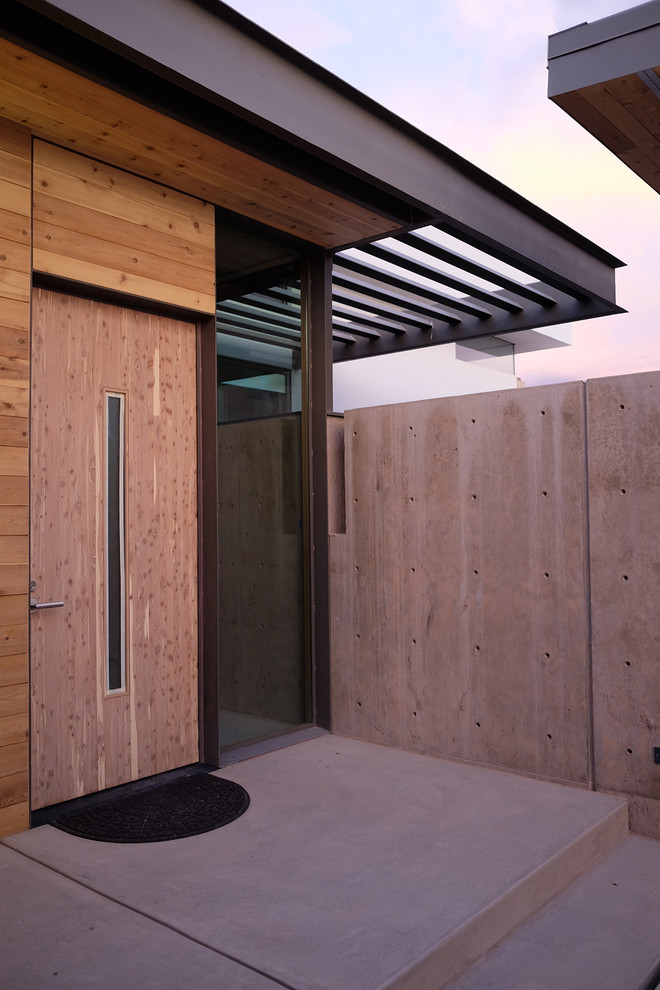 Example of a trendy concrete floor entryway design in Albuquerque with a medium wood front door