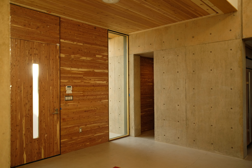 Стильный дизайн: прихожая в современном стиле с бетонным полом, одностворчатой входной дверью и входной дверью из дерева среднего тона - последний тренд