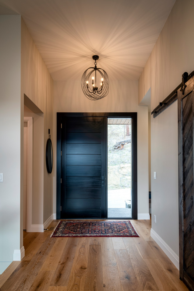 На фото: входная дверь среднего размера в современном стиле с бежевыми стенами, светлым паркетным полом, одностворчатой входной дверью, входной дверью из темного дерева и коричневым полом с