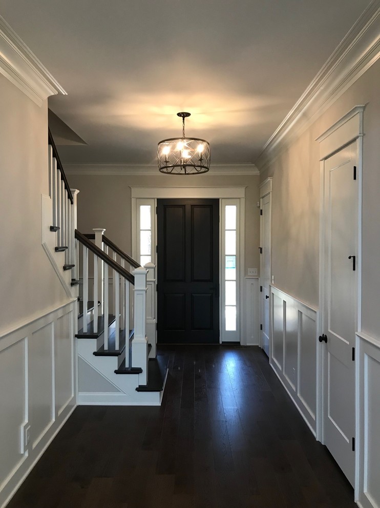 ルイビルにあるお手頃価格の中くらいなトラディショナルスタイルのおしゃれな玄関ホール (ベージュの壁、濃色無垢フローリング、濃色木目調のドア、茶色い床) の写真