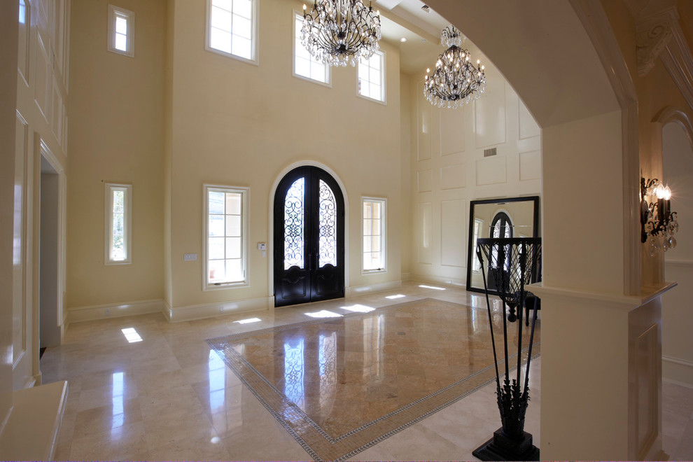 Großes Mediterranes Foyer mit beiger Wandfarbe, Keramikboden, Doppeltür, Haustür aus Glas und beigem Boden in Orange County