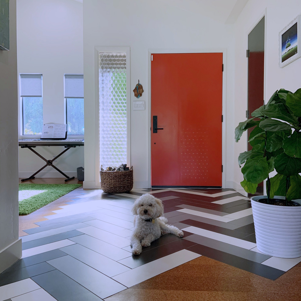 サンディエゴにある高級な中くらいなミッドセンチュリースタイルのおしゃれな玄関ロビー (白い壁、磁器タイルの床、オレンジのドア、マルチカラーの床、三角天井) の写真