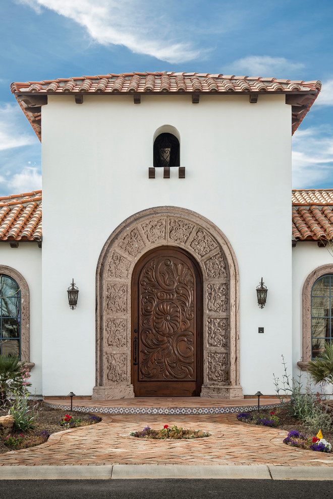 Design ideas for a mediterranean front door in Phoenix with a single front door and a dark wood front door.