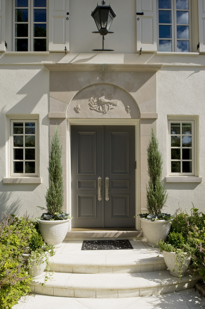 Cette photo montre une très grande porte d'entrée nature avec une porte double, une porte grise et sol en béton ciré.