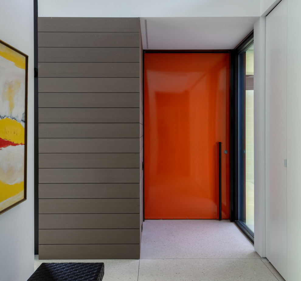 Inredning av en modern mellanstor ingång och ytterdörr, med vita väggar, betonggolv, en pivotdörr, en orange dörr och vitt golv