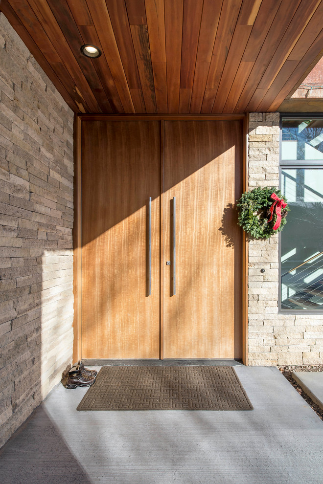 Inspiration for a large contemporary front door in Salt Lake City with beige walls, concrete flooring, a double front door and a medium wood front door.