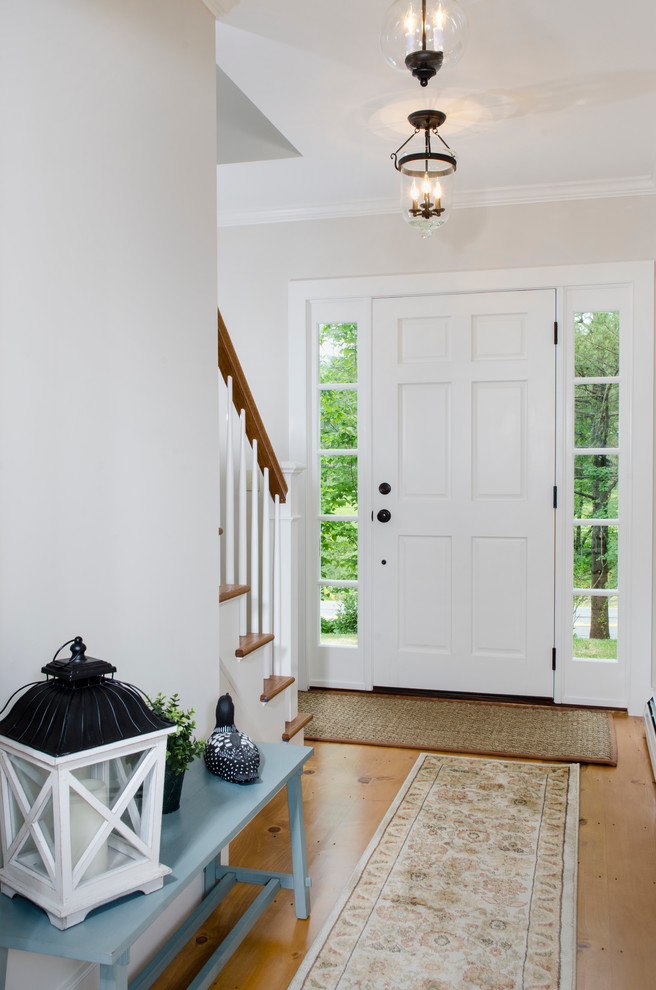 Idées déco pour une porte d'entrée campagne de taille moyenne avec parquet clair, une porte simple et une porte blanche.