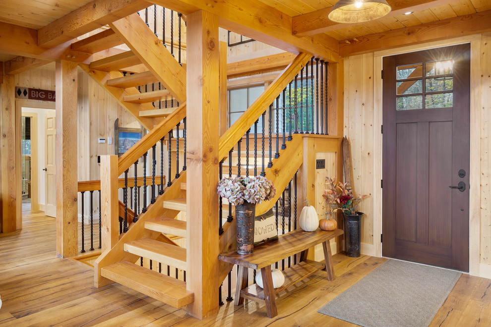 This is an example of a medium sized rustic foyer in Boston with beige walls, medium hardwood flooring, a single front door, a dark wood front door and brown floors.