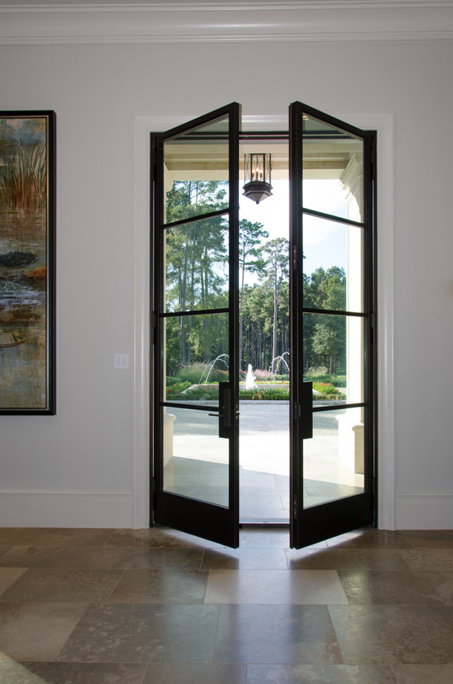 Example of a tuscan travertine floor double front door design in Houston with beige walls and a glass front door
