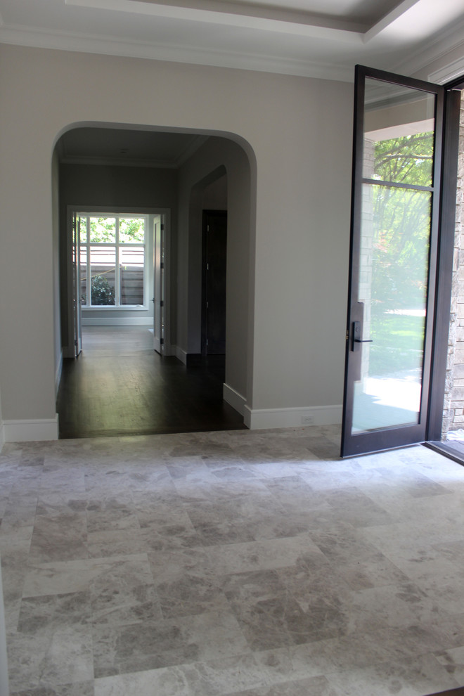 Cette image montre un hall d'entrée traditionnel de taille moyenne avec un mur blanc, un sol en marbre et un sol gris.