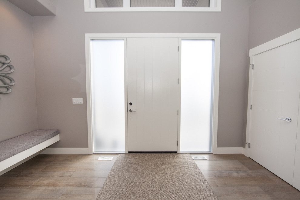 Ispirazione per un grande ingresso minimal con pareti grigie, una porta singola, una porta bianca e pavimento con piastrelle in ceramica