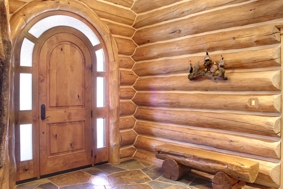 Imagen de distribuidor rural de tamaño medio con puerta simple, puerta de madera en tonos medios, paredes beige, suelo de pizarra y suelo multicolor