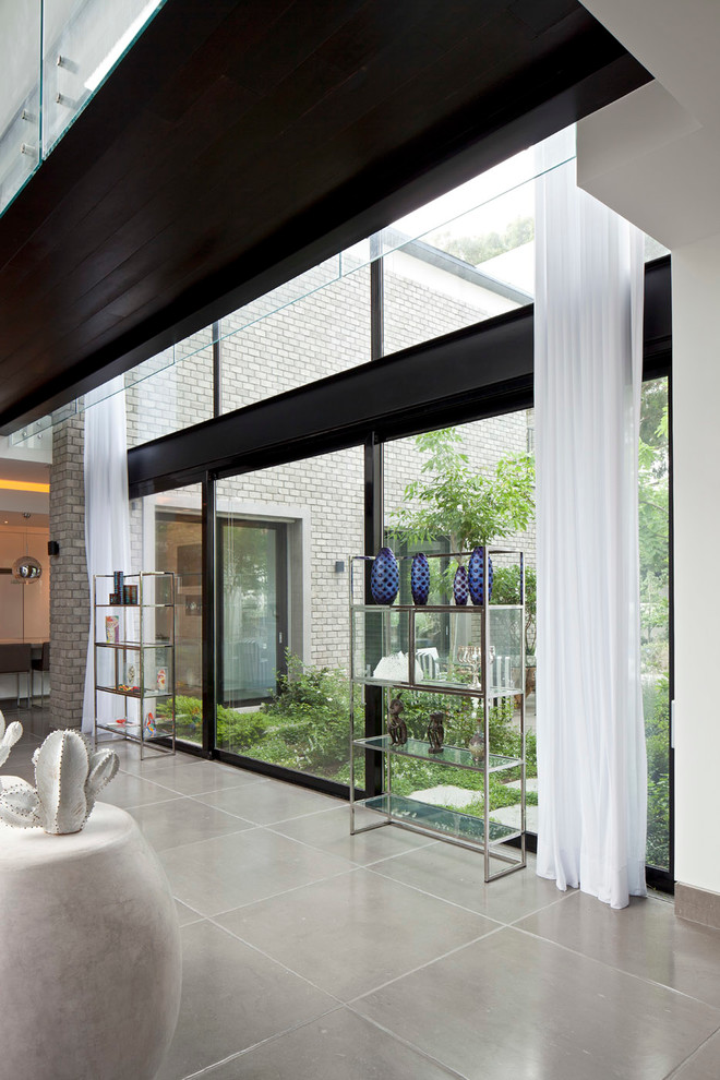 Пример оригинального дизайна: большое фойе в стиле модернизм с белыми стенами, полом из известняка, двустворчатой входной дверью и входной дверью из темного дерева