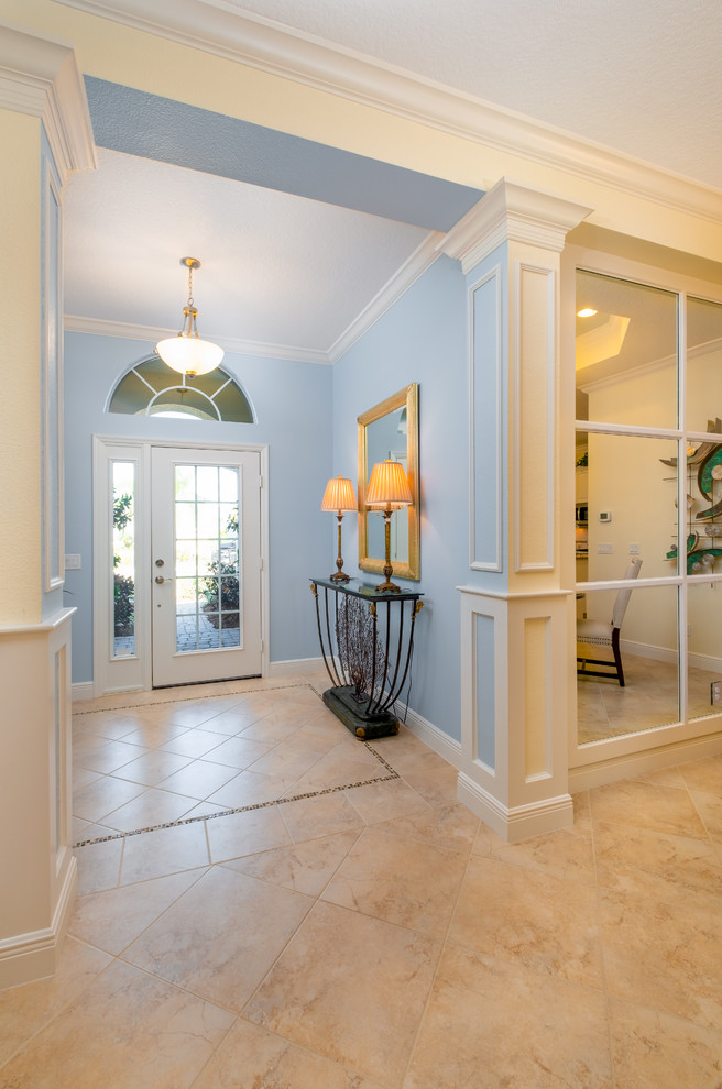Inspiration for a small classic front door in Tampa with blue walls, limestone flooring, a single front door, a glass front door and beige floors.