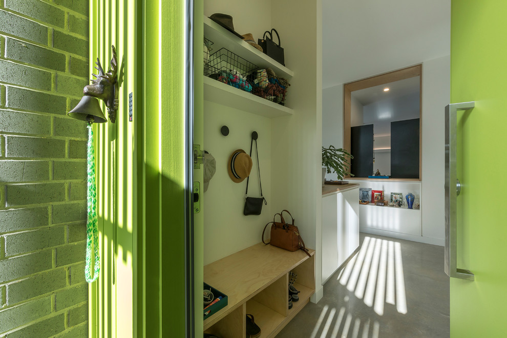 Идея дизайна: маленькое фойе в современном стиле с зелеными стенами, бетонным полом, одностворчатой входной дверью, зеленой входной дверью и серым полом для на участке и в саду
