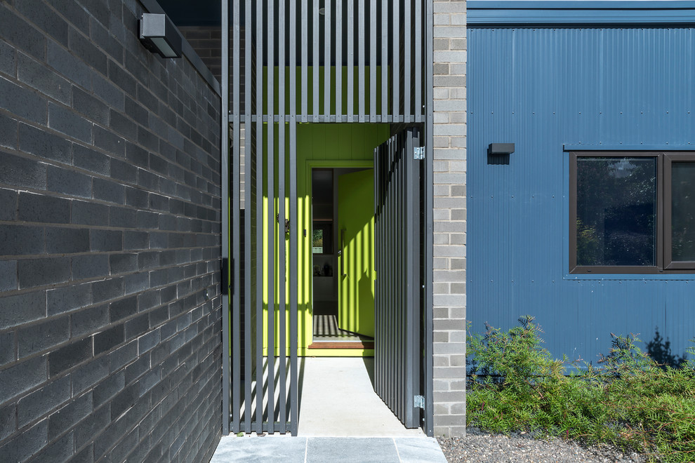 Пример оригинального дизайна: маленькое фойе в современном стиле с зелеными стенами, бетонным полом, одностворчатой входной дверью, зеленой входной дверью и серым полом для на участке и в саду