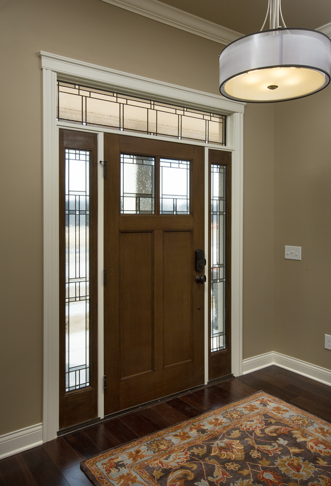 This is an example of a traditional front door in Columbus with beige walls, dark hardwood flooring, a single front door and a dark wood front door.