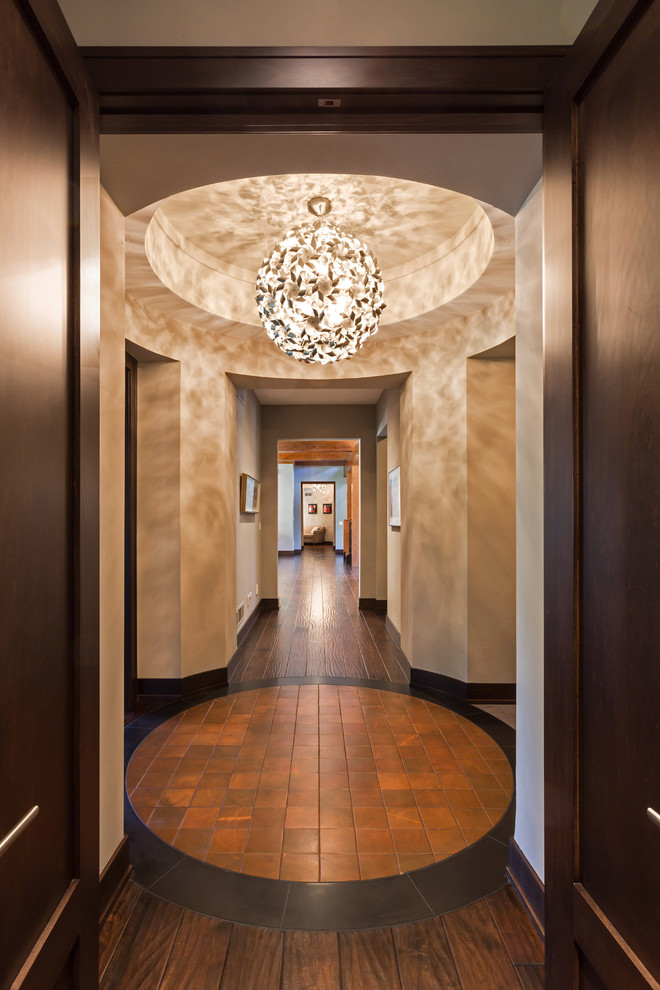This is an example of an expansive classic hallway in Milwaukee with beige walls and dark hardwood flooring.