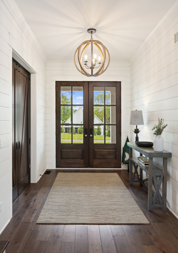 Ejemplo de entrada campestre con puerta doble, puerta de madera oscura y machihembrado