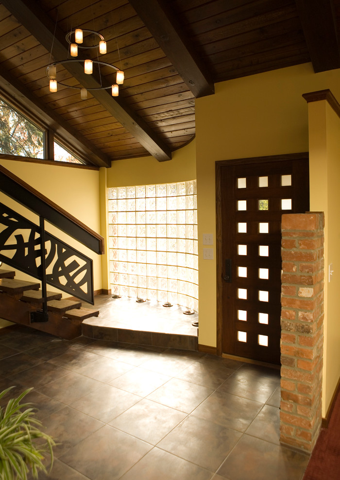 Réalisation d'une entrée design avec une porte simple et une porte en bois foncé.