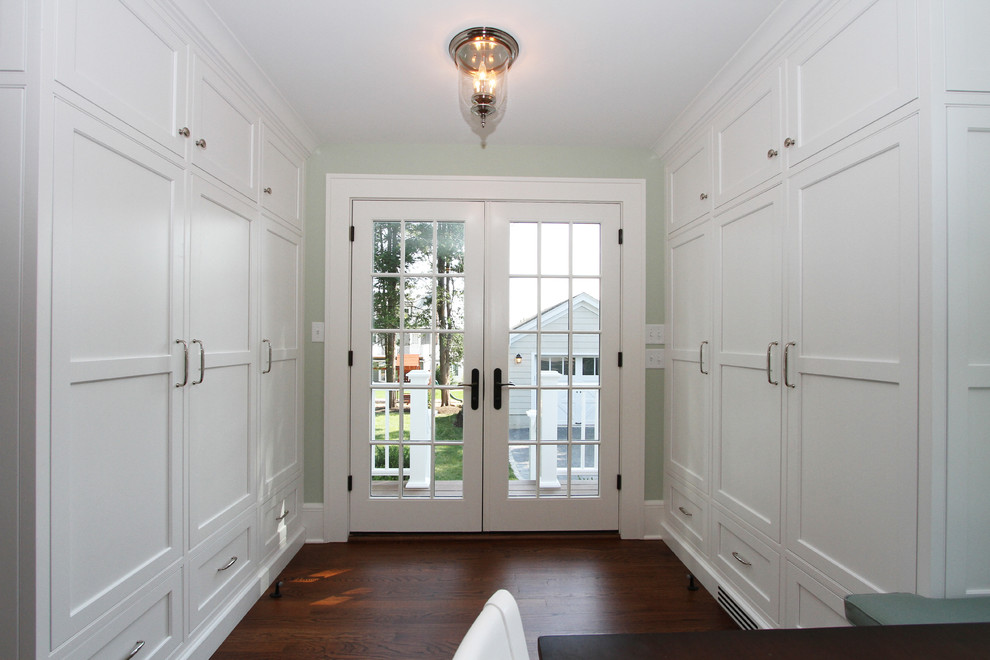 Réalisation d'une entrée tradition de taille moyenne avec un vestiaire, parquet foncé, une porte double et une porte blanche.