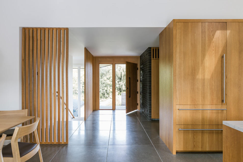 Inspiration pour un hall d'entrée vintage avec un mur blanc, une porte simple, une porte en bois brun et un sol gris.