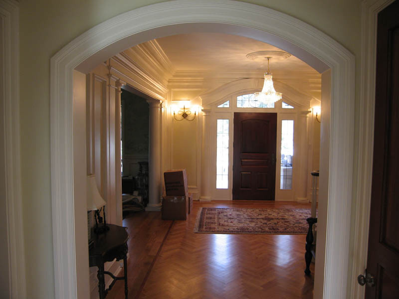 Ispirazione per una grande porta d'ingresso tradizionale con pareti gialle, pavimento in legno massello medio, una porta singola e una porta in legno scuro