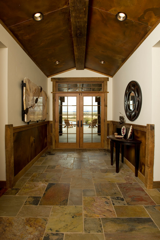 他の地域にある高級な中くらいなラスティックスタイルのおしゃれな玄関ロビー (白い壁、スレートの床、グレーの床、木目調のドア) の写真
