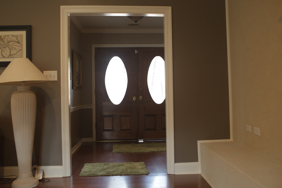 Mittelgroßes Klassisches Foyer mit brauner Wandfarbe, braunem Holzboden, Doppeltür und grauer Haustür in Jackson