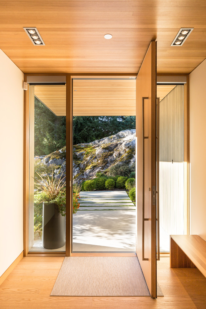 Inspiration pour une entrée minimaliste avec un couloir, un mur blanc, parquet clair, une porte simple, une porte en bois clair et un sol beige.