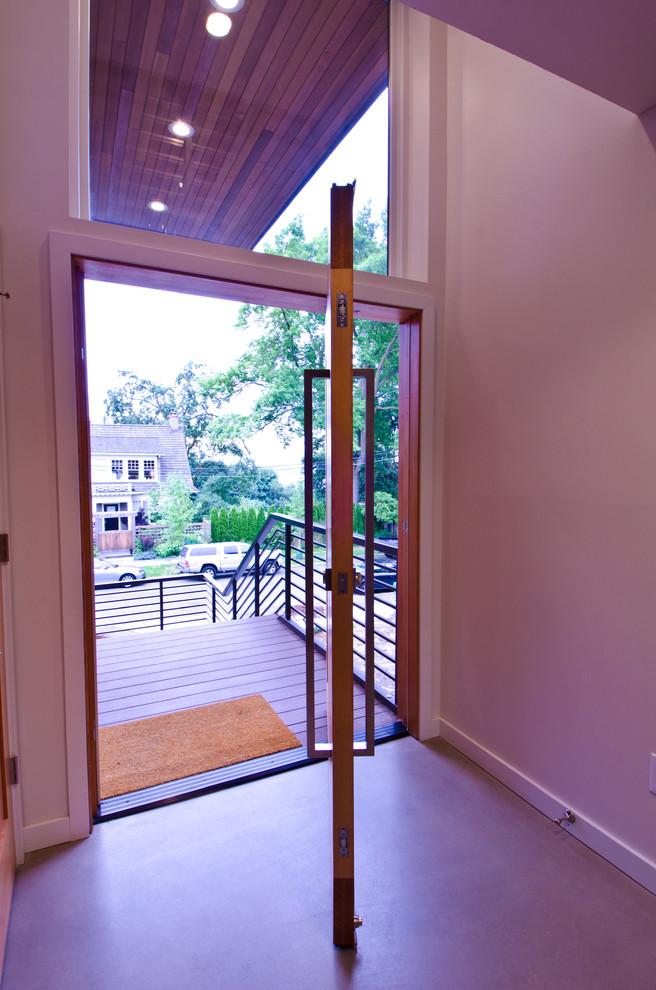 Источник вдохновения для домашнего уюта: входная дверь среднего размера в стиле модернизм с белыми стенами, бетонным полом, поворотной входной дверью и входной дверью из дерева среднего тона