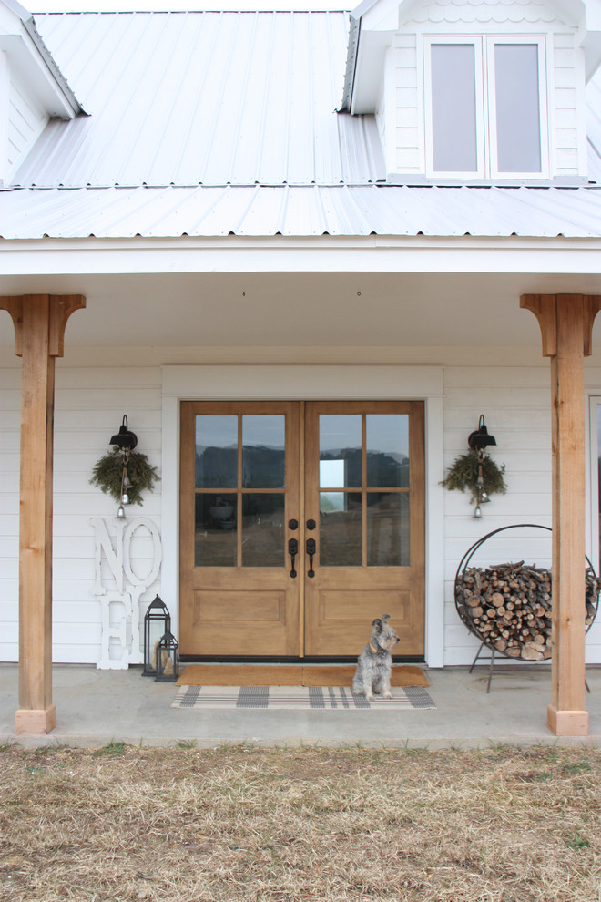 Diseño de entrada campestre con paredes blancas, puerta doble y puerta de madera en tonos medios