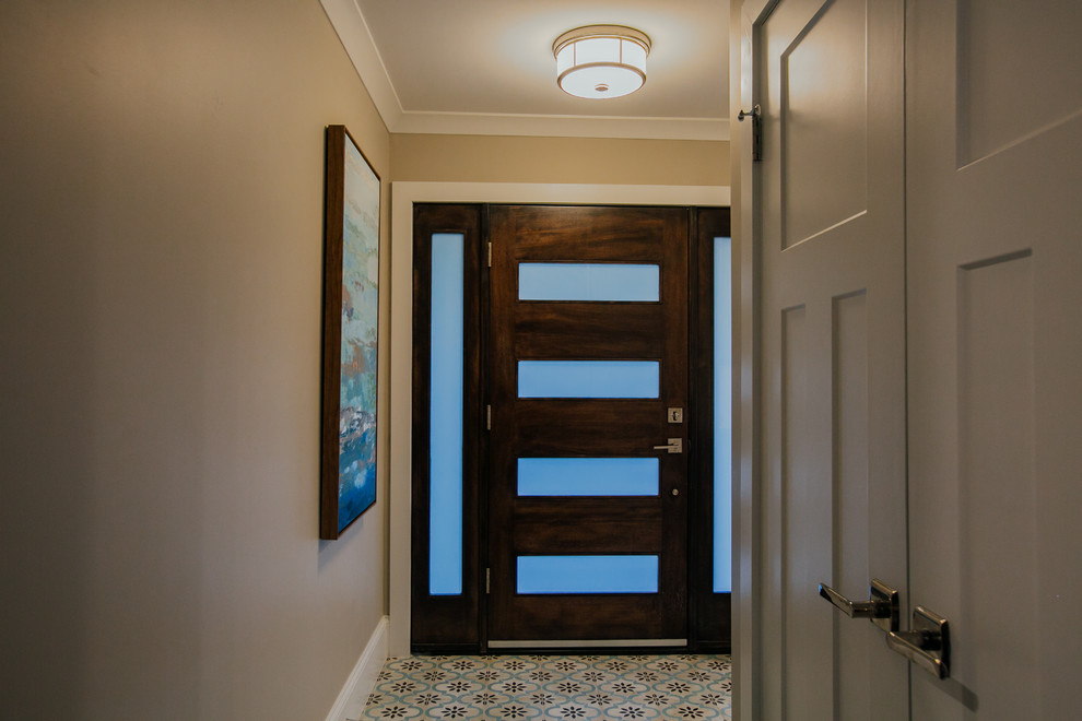 デンバーにある高級な中くらいなトランジショナルスタイルのおしゃれな玄関ロビー (グレーの壁、磁器タイルの床、木目調のドア、マルチカラーの床) の写真