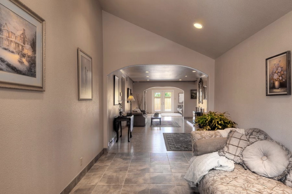 Classic foyer in Salt Lake City with beige walls, ceramic flooring, a single front door, a medium wood front door, grey floors and a vaulted ceiling.