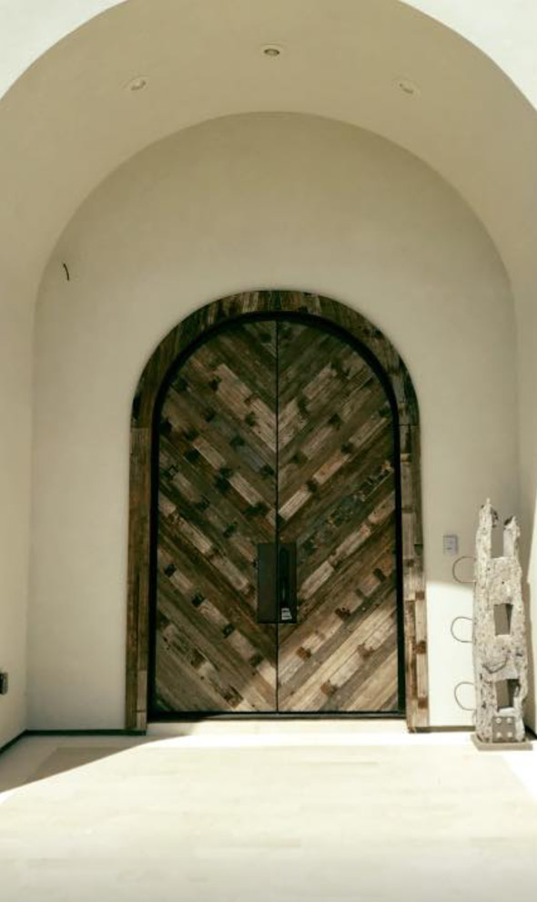 Bild på en stor ingång och ytterdörr, med vita väggar, målat trägolv, en dubbeldörr, mörk trädörr och beiget golv