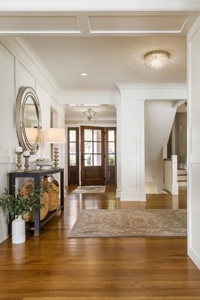 Large classic hallway in Minneapolis with white walls, medium hardwood flooring, a single front door, a medium wood front door and brown floors.
