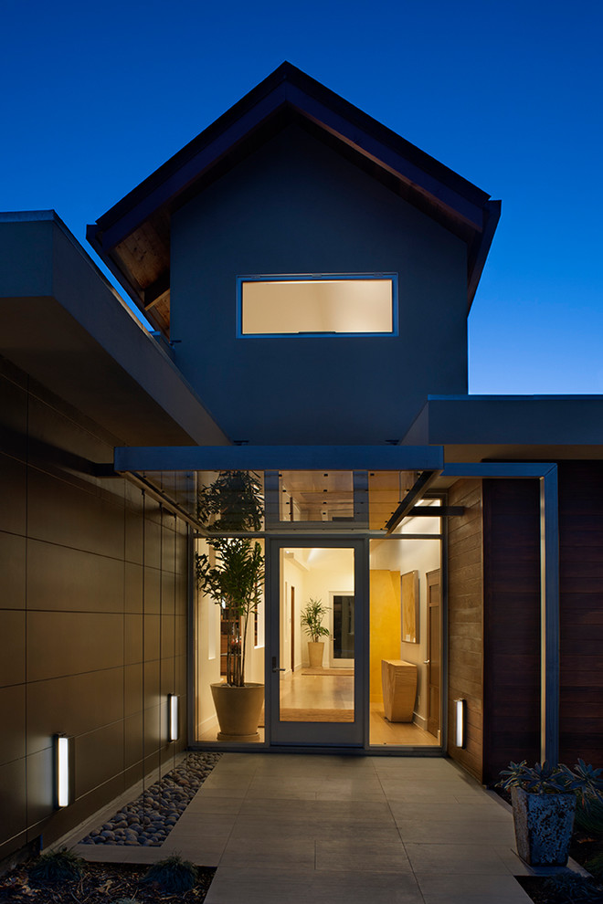 Idée de décoration pour une porte d'entrée minimaliste avec sol en béton ciré, une porte simple et une porte en verre.