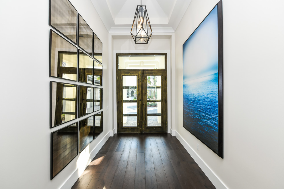 Esempio di un corridoio stile marinaro di medie dimensioni con pareti grigie, pavimento in legno massello medio, una porta a due ante, una porta in legno scuro e pavimento marrone