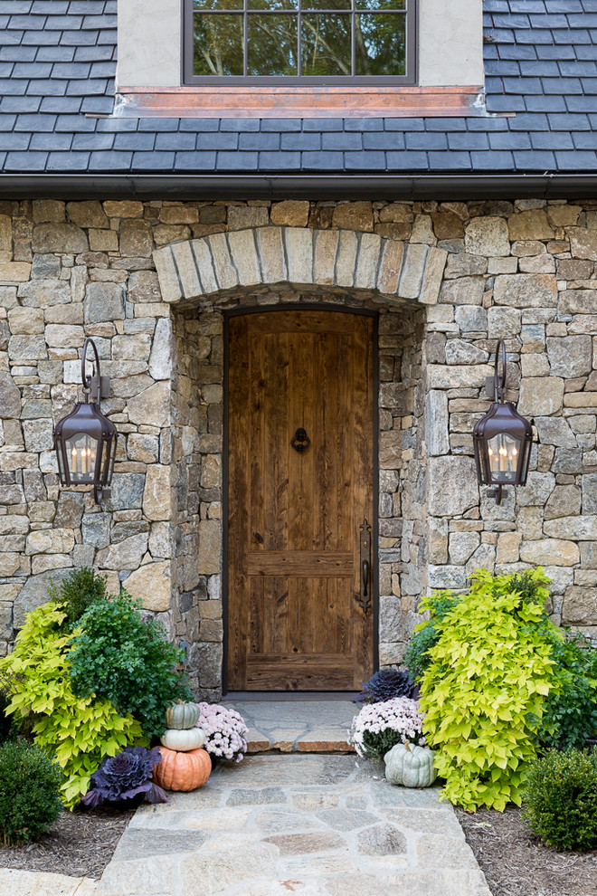 Пример оригинального дизайна: входная дверь в стиле рустика с серыми стенами, одностворчатой входной дверью, входной дверью из дерева среднего тона и серым полом